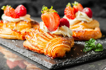 Delicious flaky fresh baked Danish Pastry with Chantilly cream and fresh fruit.の写真素材