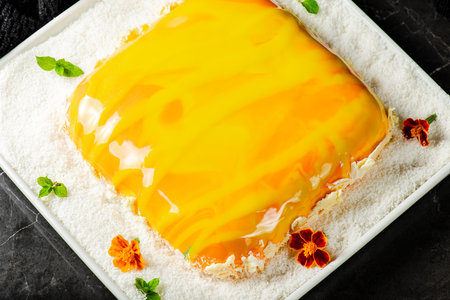 Gourmet Entremet Cake with layered sponge cake, mango jelly, coconut cream jelly and vanilla mousse, covered in a tropical coloured mirror glaze.の写真素材