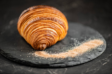 Close-up of crispy, flaky, and delicious butter croissant coated in cinnamon sugar.の写真素材