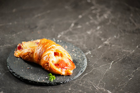 Viennoiserie pastry filled with smoked and baked fresh ham off the bone and tasty cheese.の写真素材