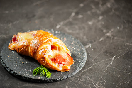 Viennoiserie pastry filled with smoked and baked fresh ham off the bone and tasty cheese.の写真素材