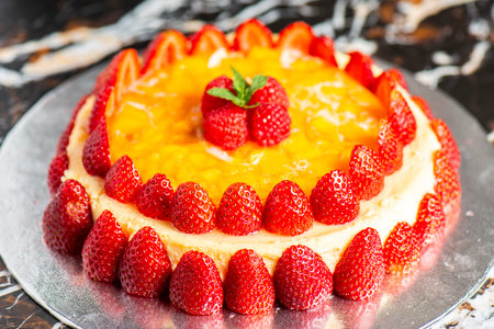 Melt in your mouth, rich and delicious fresh baked mascarpone cheesecake with summer fruits and mango jelly.の写真素材