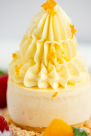 Soft and creamy orange and ricotta cheesecake accompanied with fresh fruit.の写真素材