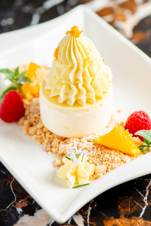 Soft and creamy orange and ricotta cheesecake accompanied with fresh fruit.の写真素材
