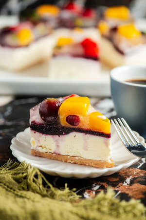 Delicious and light no-bake cheesecake with summer fruits including strawberry, mango, and grapes.の写真素材