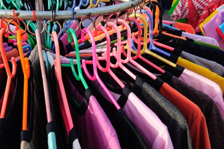 Colorful t-shirts on the hanger in the clothes shopの写真素材