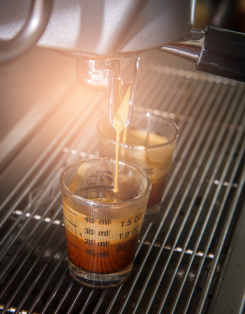 espresso coffee machine with filter make coffee flowing into a cup. hot coffee flowing to coffee cup.の写真素材