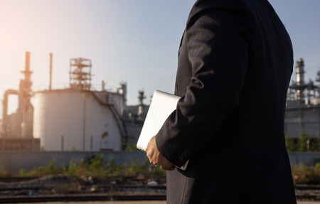 Engineering with tablet work at the oil refinery, check the informationの写真素材