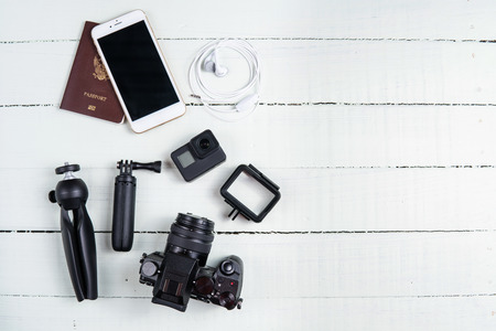 top view travel concept with camera, passport and travel accessories on white wooden table...