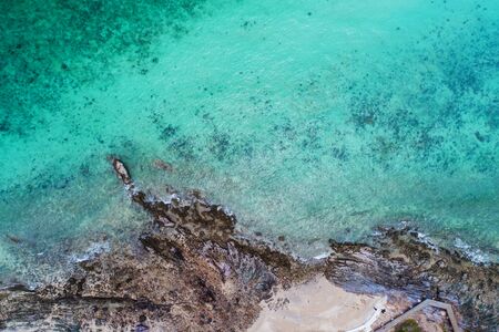 Aerial top view of ocean waves, beach and rocky coastline and beautiful forest. Beautiful nature background. island background and tropical with touristの写真素材