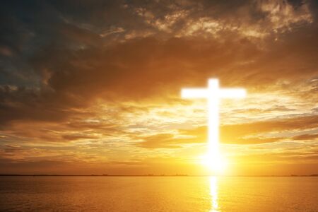 Conceptual wood cross or religion symbol shape over a sunset sky with clouds background for God. belief or resurrection of god and worship christian. sky freedom.の写真素材