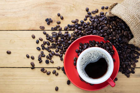 Hot coffee espresso or americano and coffee bean on older wood table at morning time. Coffee break...