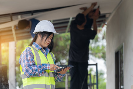 Real working engineering. Worker or engineering checking blueprint and planning to renovation, Female foreman in safety helmet and study blueprint for redecorating house.の写真素材