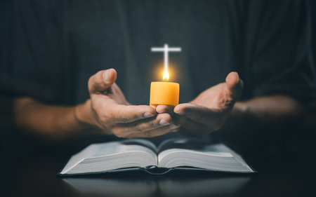 Christian man worship. Hands folded in prayer on a Holy Bible in home concept for faith....