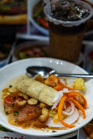 Authentic Vietnamese BÃ¡nh$ Cuá»n Trá»n (mixed rice noodle rolls) topped with Vietnamese sausage, crispy shallots, and pickled vegetables, served with a rich sauce.の写真素材