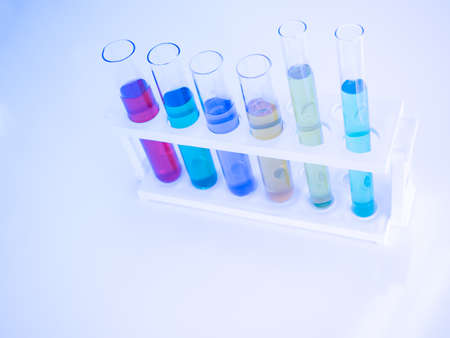 The test tube has a multicolored liquid inside. Put on a table for science experiments, color tones.の写真素材
