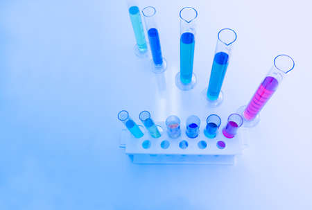 The test tube has a multicolored liquid inside. Put on a table for science experiments, color tones.の写真素材