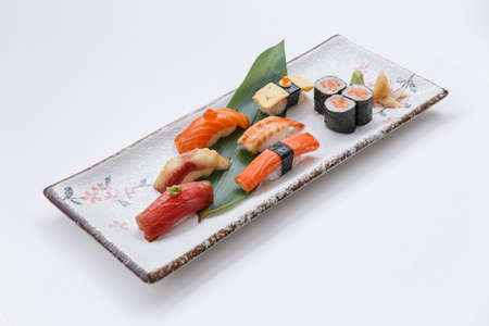 Sushi Set Include Maguro, Hamachi, Salmon, Kani, Shrimp and Tamago Maki with Salmon Maki Rolls Served with Prickled Ginger and Wasabi in Japanese Painted Stone Plate.の写真素材