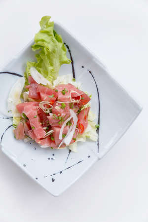 Raw Maguro (Bluefin Tuna) Spicy Salad in Japanese Painted Ceramic Dish.の写真素材