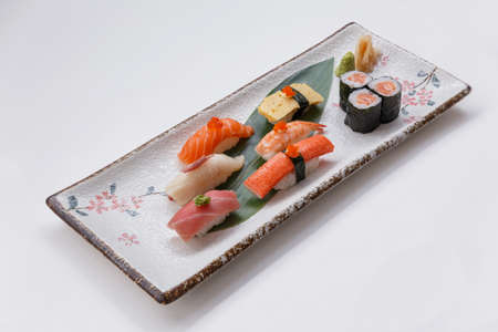 Sushi Set Include Maguro, Hamachi, Salmon, Kani, Shrimp, Tamagoyaki and Salmon Maki Roll Served with Wasabi and Prickled Ginger on Japanese Painted Stone Plate.の写真素材