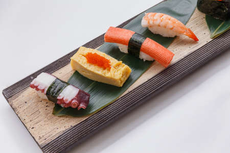 Sushi Set Include Shrimp, Kani, Tamagoyaki with Squid Served on Leaf on Stone Plate.の写真素材