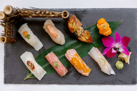 Premium Sushi Set Include Engawa, Hamachi, Hotate, Toro, Foie Gras, Salmon, Sea Urchin and Tai Served with Wasabi and Prickled Ginger on The Black Stone Plate.の写真素材