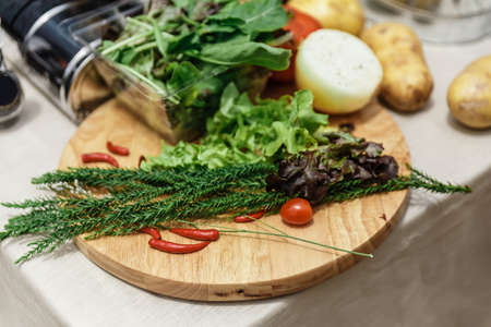 Fresh Ingredients Include Rosemary, Onion, Tomato, Potato and Vegetables on Wood Block.の写真素材