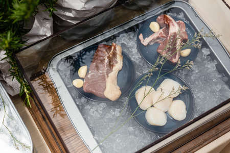 Beef, Pork and Scallop with Garlic on Iced Plate for Making Steaks in Glass Box.の写真素材