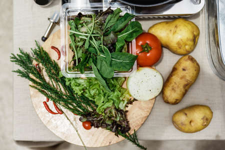 Fresh Ingredients Include Rosemary, Onion, Tomato, Potato and Vegetables on Wood Block.の写真素材