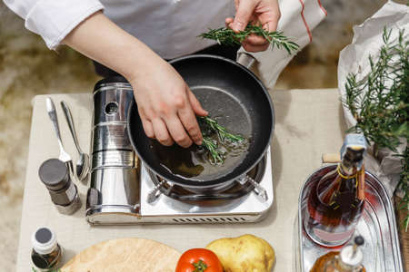 Chef Fried Rosemary Leaves in Olive Oil in a Pan for Making Rosemary Oil.の写真素材