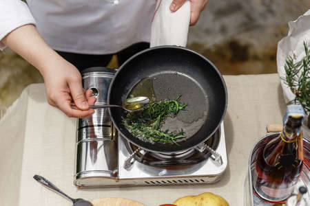 Chef Fried Rosemary Leaves in Olive Oil in a Pan for Making Rosemary Oil.の写真素材