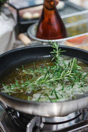 Chef Fried Rosemary Leaves in Olive Oil in a Pan for Making Rosemary Oil.の写真素材