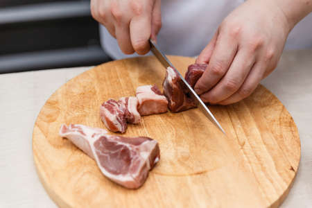 Chef Cutting Raw Meat on The Wood Block.の写真素材