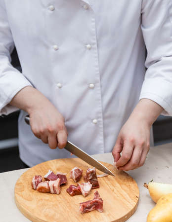 Chef Cutting Raw Meat on The Wood Block.の写真素材