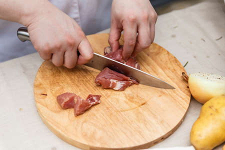 Chef Cutting Raw Meat on The Wood Block.の写真素材