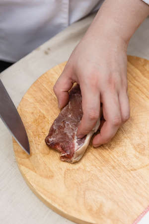Chef Cutting Raw Meat on The Wood Block.の写真素材