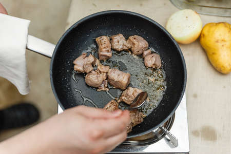 Chef Fried Marinated Diced Raw Beef in Pan with Rosemary Oil with Spoon.の写真素材