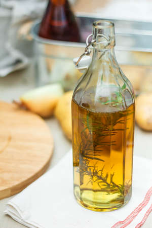 Rosemary Oil in The Glass Bottle on Folded Napkin with Fresh Rosemary inside.の写真素材