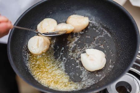 Chef Fried Scallops with Rosemary Oil in Pan with Spoon.の写真素材