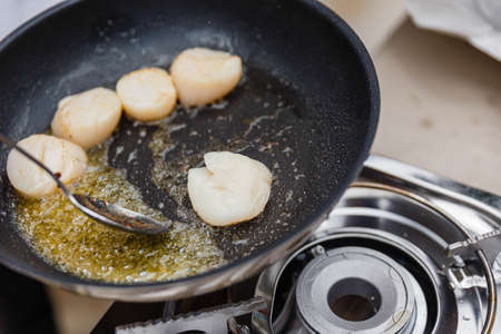 Chef Fried Scallops with Rosemary Oil in Pan with Spoon.の写真素材