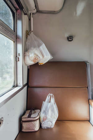 Thai Train Seat that near the Window with Food in Plastic Bags and Fabric Bags.の写真素材