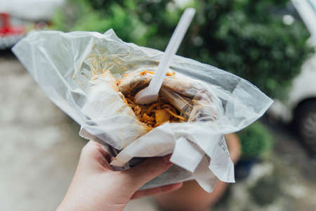 Mi Goreng in Paper Wrapped with Plastic Fork from Street Food of George Town. Penang, Malaysia.の写真素材