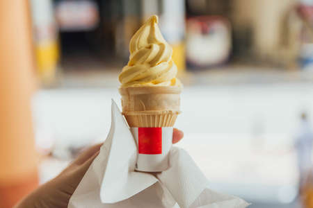 Pineapple yellow ice-cream cone with napkin in George Town. Penang, Malaysia.の写真素材