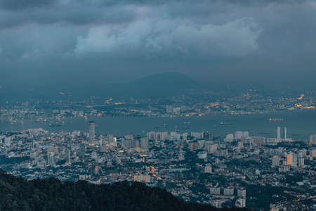 Dusk cloudy sky, cityscape and mountain with green that viewed from Penang Hill at George Town. Penang, Malaysia.の写真素材