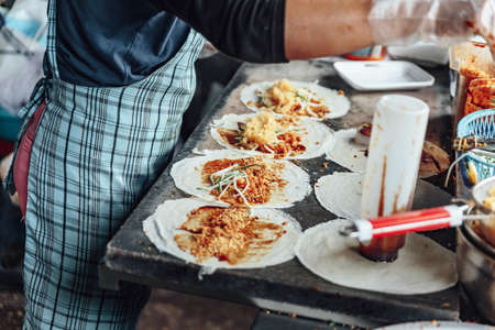 Making unfried spring roll including sauce, bean sprout, lettuce, chinese sausage and freid egg inside in in Kuala Lumnpur, Malaysia.の写真素材