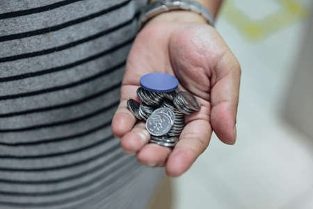 The change of Ringgit coins with train's token in left hand in Kuala Lumpur, Malaysia.