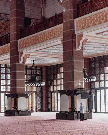 A man is praying in Putra Mosque in Wilayah Persekutuan Putrajaya, Malaysiaのeditorial素材