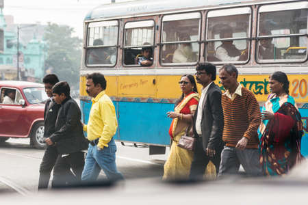 People cross the road with many cars in Kolkata, Indiaのeditorial素材
