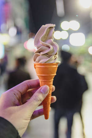 Soft serve ice cream in cone with left hand in winter at Lachen. North Sikkim, India.