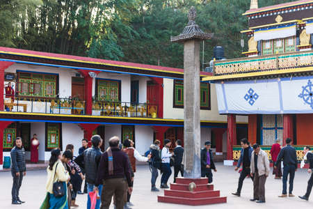 Tourists toss many coin to the top of stone pillar for lucky  in the center of Rumtek Monastery in winter near Gangtok. Sikkim, India.のeditorial素材